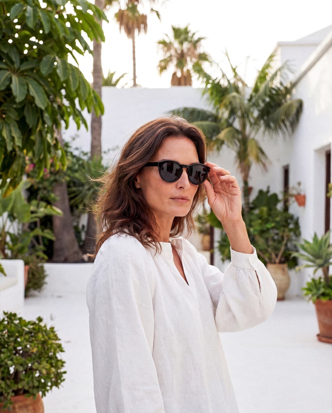 Model wearing black sunglasses in an outdoor lifestyle campaign image