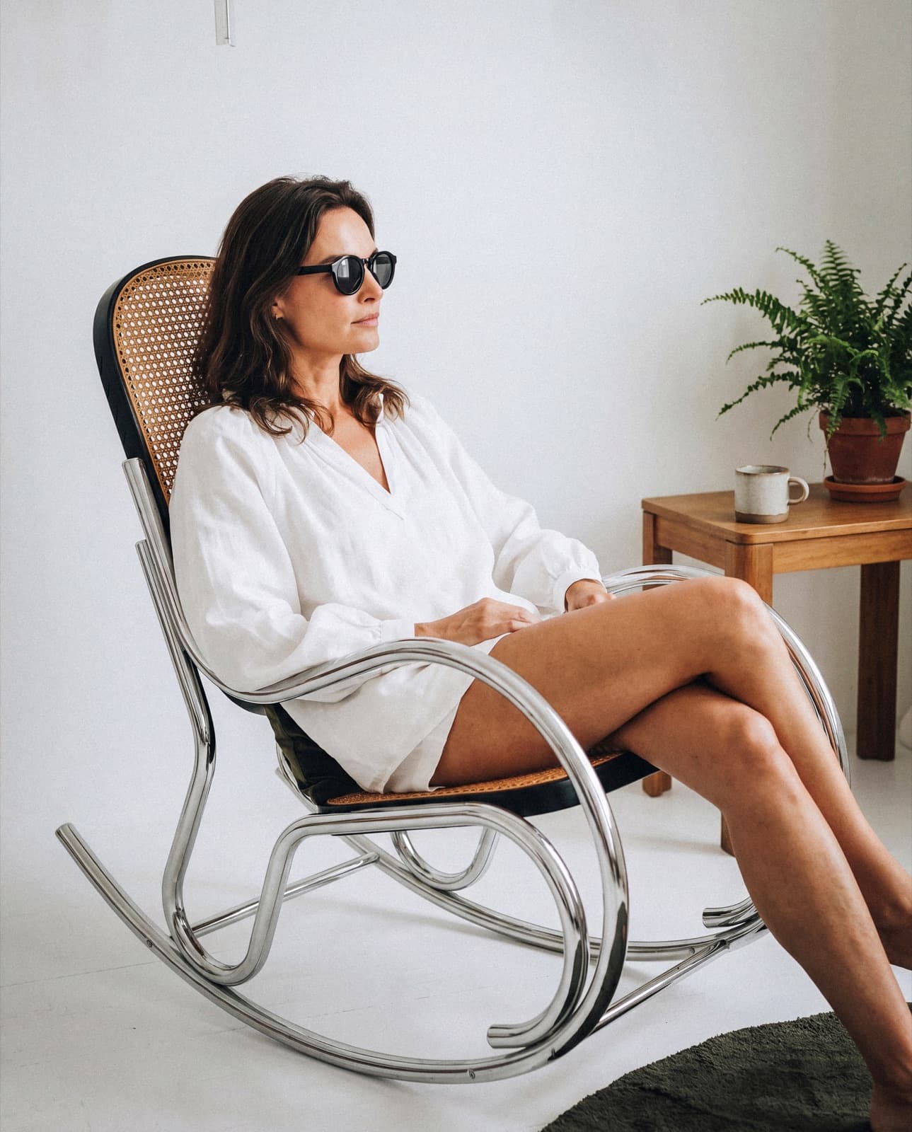 Model wearing black sunglasses in an indoor lifestyle campaign image